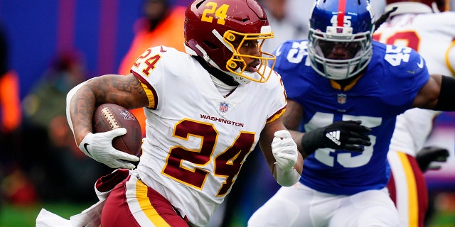 Washington Football Team running back Antonio Gibson (24) runs the ball with New York Giants middle linebacker Jaylon Smith (45) in pursuit during the first quarter Sunday, 1 월. 9, 2022, 이스트 러더퍼드에서, N.J.