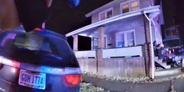 Still from body camera footage showing James Williams' family huddled on their steps 