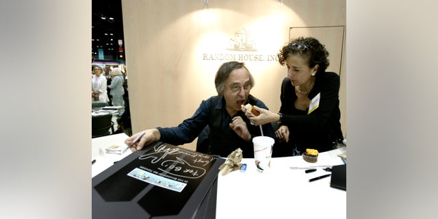 Artist and author Art Spiegelman gets some help with his lunch from Francoise Mouly, of Random House Inc., during a signing of Spiegelman's new book "In the Shadow of No Towers" at the Book Expo America convention, Saturday, June 5, 2004, in Chicago. 