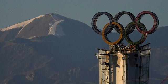 Cincin Olimpiade yang dipasang di atas menara yang menonjol di dekat resor ski di pinggiran Beijing, Cina, Kamis, 28 Januari.  13, 2022.