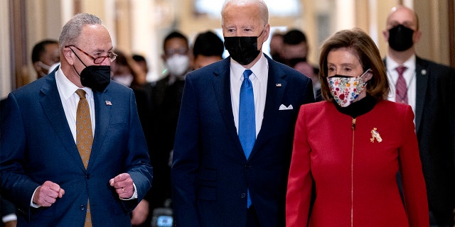 President Biden walks with Senate Majority Leader Chuck Schumer of N.Y., left, and House Speaker Nancy Pelosi of Calif., right, as he arrives at the U.S. Capitol to mark one year since the Jan. 6 riot at the Capitol by supporters loyal to then-President Donald Trump, Thursday, Jan. 6, 2022, in Washington. 