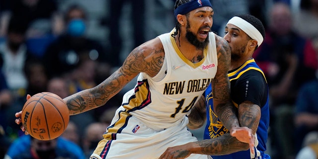 New Orleans Pelicans forward Brandon Ingram (14) drives to the basket against Golden State Warriors guard Gary Payton II in the first half of an NBA basketball game in New Orleans, 星期四, 一月. 6, 2022.