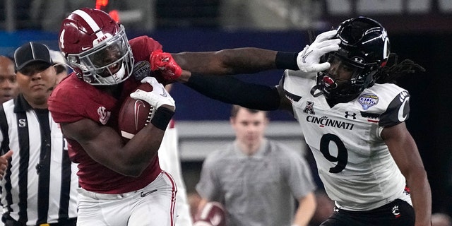 Cincinnati cornerback Arquon Bush (9) tries to tackled Alabama running back Brian Robinson Jr. (4) during the first half of the Cotton Bowl NCAA College Football Playoff semifinal game, Vrydag, Des. 31, 2021, in Arlington, Texas.
