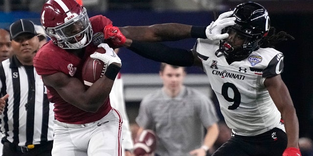 Cincinnati cornerback Arquon Bush (9) tries to tackled Alabama running back Brian Robinson Jr. (4) during the first half of the Cotton Bowl NCAA College Football Playoff semifinal game, Venerdì, Dic. 31, 2021, ad Arlington, Texas.