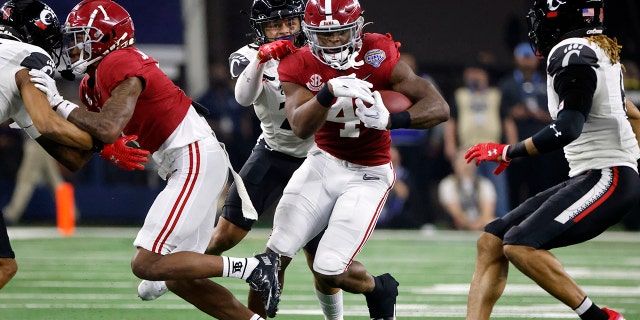 Alabama running back Brian Robinson Jr. (4) runs for a first down as Cincinnati linebacker Deshawn Pace reaches from behind to tackle him during the first half of the Cotton Bowl NCAA College Football Playoff semifinal game, Venerdì, Dic. 31, 2021, ad Arlington, Texas. Alabama won 27-6.