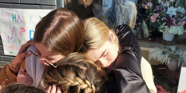 Friends of Brianna Kupfer share an emotional embrace during a vigil Thursday. 