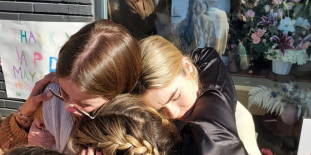 Friends of Brianna Kupfer share an emotional embrace during a vigil Thursday.