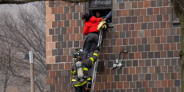 Firefighters hoisted a ladder to rescue people through their windows after a fire broke out inside a third-floor duplex apartment at 333 E. 181st St. in the Bronx Sunday. (Theodore Parisienne/New York Daily News/Tribune News Service via Getty Images)