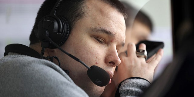 Bryce Weiler, a blind sports commentator, brings his phone closer to his ear as he announces a few innings for Georgia Tech during a game against the University of Illinois at Chicago at Curtis Granderson Stadium in Chicago on April 28, 2017. 