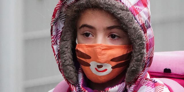 A child wearing a mask arrives at school during the COVID-19 pandemic in the Manhattan borough of New York City Jan. 5, 2022.