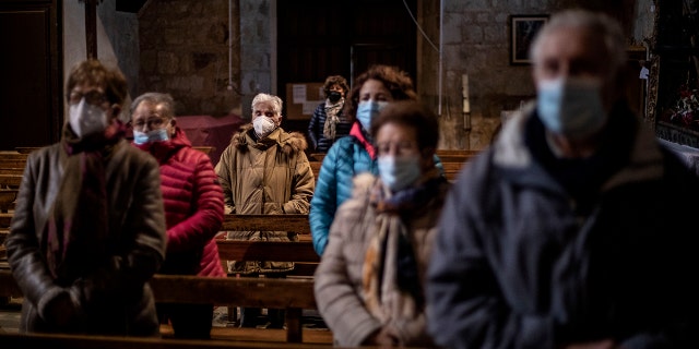 Parishioners stand while praying at the Saturday Mass the Catholic church of Cazurra, Spain