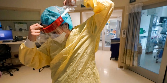 Registered nurse Sara Nystrom, of Townshend, Vt., prepares to enter a patient's room in the COVID-19 Intensive Care Unit at Dartmouth-Hitchcock Medical Center, in Lebanon, N.H., Jan. 3, 2022. 