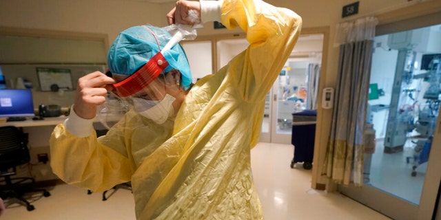 Registered nurse Sara Nystrom, of Townshend, Vt., prepares to enter a patient's room in the COVID-19 Intensive Care Unit at Dartmouth-Hitchcock Medical Center, in Lebanon, New Hampshire, Jan. 3, 2022. 