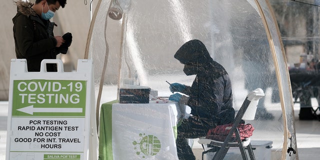 A person visits a Covid-19 testing site along a Manhattan street on January 21, 2022 in New York City. (Photo by Spencer Platt/Getty Images)