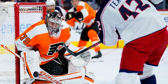 Philadelphia Flyers' Carter Hart, izquierda, blocks a shot by Columbus Blue Jackets' Alexandre Texier during the first period of an NHL hockey game, jueves, ene. 20, 2022, en Filadelfia.