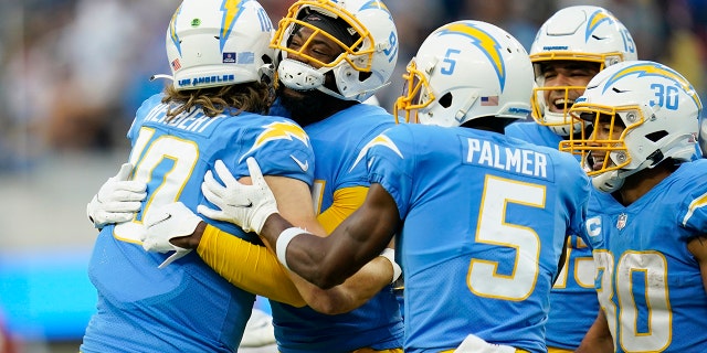 Los Angeles Chargers quarterback Justin Herbert (10) hugs wide receiver Mike Williams after Williams' touchdown catch during the second half of an NFL football game against the Denver Broncos Sunday, Jan. 2, 2022, in Inglewood, California.