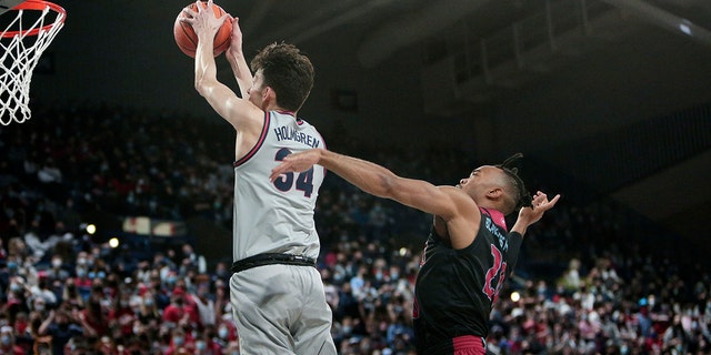 Gonzaga center Chet Holmgren, izquierda, goes up for a dunk in front of Loyola Marymount guard Cam Shelton during the first half of an NCAA college basketball game, jueves, ene. 27, 2022, in Spokane, Lavar.