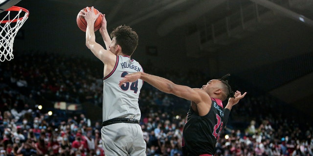 Gonzaga center Chet Holmgren, izquierda, goes up for a dunk in front of Loyola Marymount guard Cam Shelton during the first half of an NCAA college basketball game, jueves, ene. 27, 2022, in Spokane, Lavar.