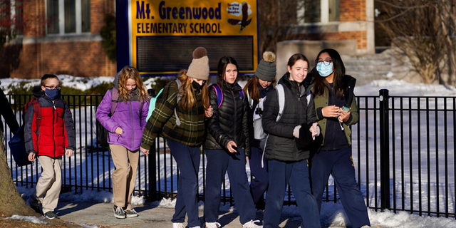 Students at the Mt. Greenwood Elementary School in Chicago depart after a full day of classes Monday, Jan. 10, 2022. (AP Photo/Charles Rex Arbogast) 