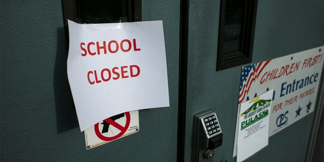 A sign taped to the front door of Pulaski International School of Chicago reads, 'School Closed,' after Chicago Public Schools, the nation's third-largest school district, said it would cancel classes.