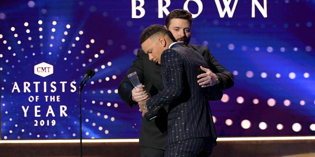 Chris Young presents award winner Kane Brown on stage at the 2019 CMT Artist of the Year.