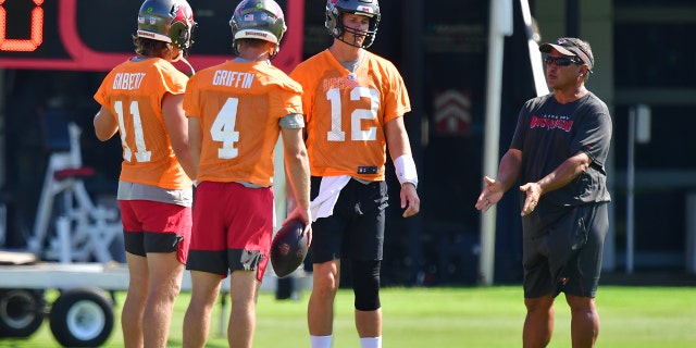 Blaine Gabbert #11, Ryan Griffin #4, and Tom Brady #12 of the Tampa Bay Buccaneers meet with quarterback coach Clyde Christensen during the Buccaneers Mini-Camp at AdventHealth Training Center on June 10, 2021 in Tampa, Florida.