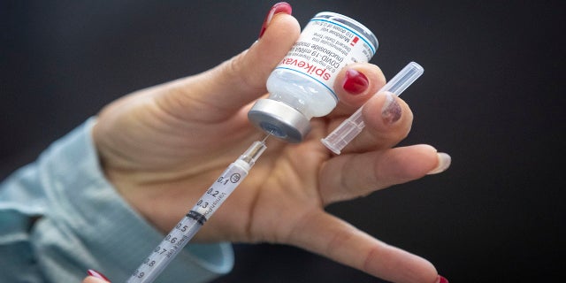 A person draws out Moderna vaccine during a drive through COVID-19 vaccine clinic at St. Lawrence College in Kingston, Ontario, on Sunday.