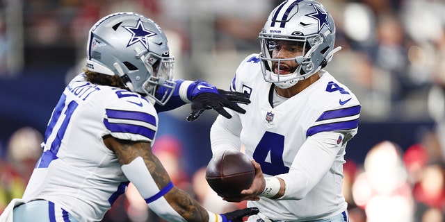 Dak Prescott #4 of the Dallas Cowboys hands the ball off to Ezekiel Elliott #21 of the Dallas Cowboys during the second quarter against the San Francisco 49ers in the NFC Wild Card Playoff game at AT&amp;T Stadium on January 16, 2022 in Arlington, Texas.
