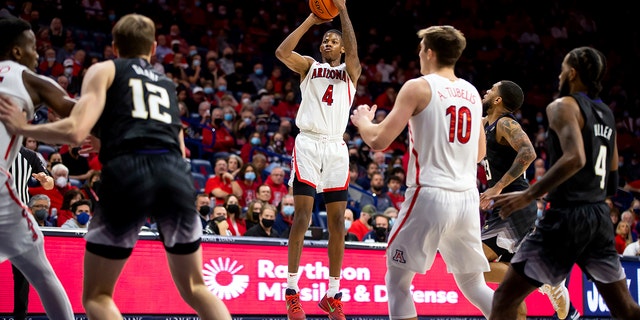 Arizona guard Dalen Terry (4) shoots a three-point basket against Washington during the first half of an NCAA college basketball game in Tucson, Ariz., Monday, Jan. 3, 2022. 