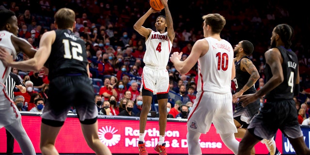 Arizona guard Dalen Terry (4) shoots a three-point basket against Washington during the first half of an NCAA college basketball game in Tucson, Ariz., Monday, Jan. 3, 2022.