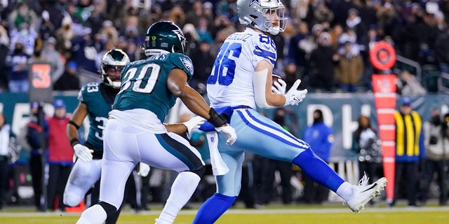Dallas Cowboys tight end Dalton Schultz, right, catches a touchdown pass over Philadelphia Eagles linebacker JaCoby Stevens, left, during the first half of an NFL football game, Saturday, Jan. 8, 2022, in Philadelphia. (AP Photo/Julio Cortez)