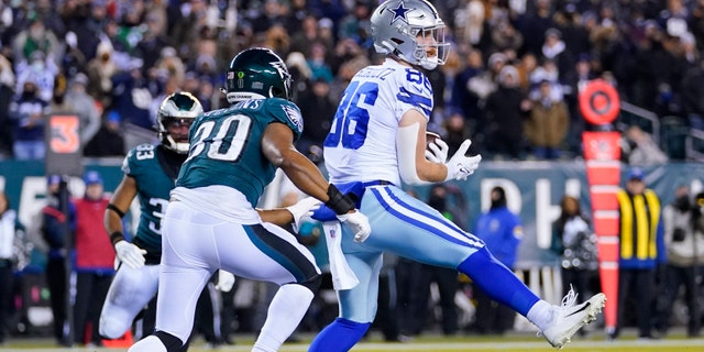 Dallas Cowboys tight end Dalton Schultz, right, catches a touchdown pass over Philadelphia Eagles linebacker JaCoby Stevens, left, during the first half of an NFL football game, Saturday, Jan. 8, 2022, in Philadelphia. (AP Photo/Julio Cortez)
