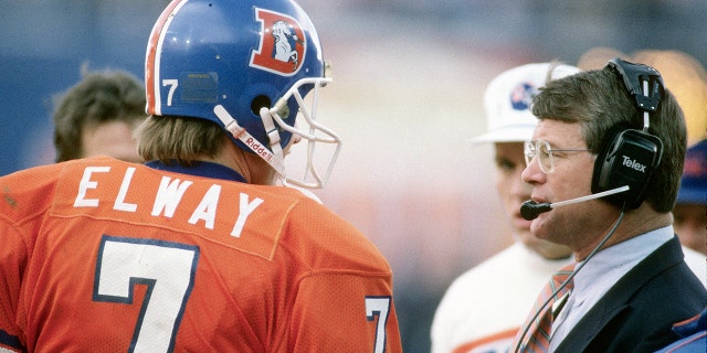 Head coach Dan Reeves of the Denver Broncos talks with his quarterback John Elway circa 1988 at Mile High Stadium in Denver, Colorado. Reeves was the head coach of the Denver Broncos from 1981-92.