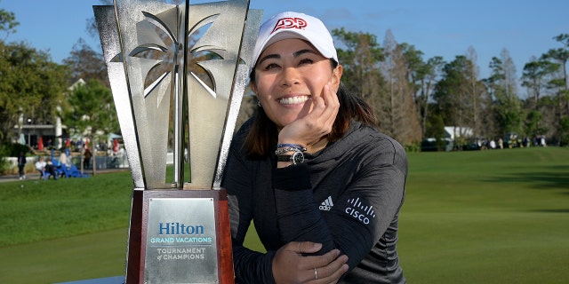 Danielle Kang poses next to the championship trophy on the 18th green after winning the Tournament of Champions LPGA golf tournament, domingo, ene. 23, 2022, en orlando, Fla.