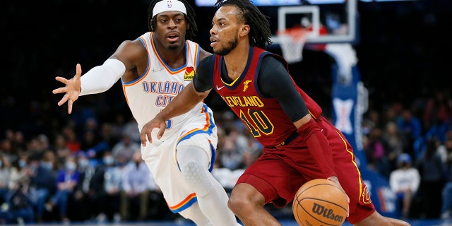 Cleveland Cavaliers guard Darius Garland (10) drives against Oklahoma City Thunder guard Luguentz Dort in the first half of an NBA basketball game Saturday, 一月. 15, 2022, 在俄克拉荷马城.