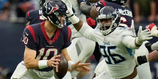 Houston Texans quarterback Davis Mills (10) is pressured by Tennessee Titans defensive end Denico Autry (96) during the second half Sunday, Jan. 9, 2022, in Houston.