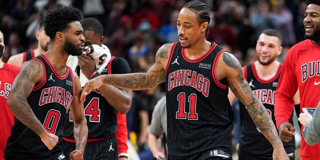Chicago Bulls' DeMar DeRozan (11) celebrates with Coby White (0) after DeRozan hit the game winning shot during an NBA basketball game against the Indiana Pacers, Friday, Dec. 31, 2021, in Indianapolis. Chicago won 108-106.
