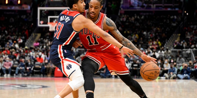 Chicago Bulls forward DeMar DeRozan (11) drives to the basket against Washington Wizards guard Tremont Waters (51) during the first half of an NBA basketball game, Saterdag, Jan.. 1, 2022, in Washington.