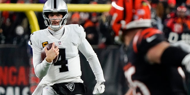 Las Vegas Raiders quarterback Derek Carr runs during the first half of an NFL wild-card playoff football game against the Cincinnati Bengals, 星期六, 一月. 15, 2022, 在辛辛那提.