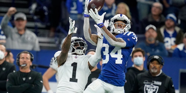 Indianapolis Colts cornerback Isaiah Rodgers (34) intercepts a pass intended for Las Vegas Raiders wide receiver DeSean Jackson (1) during the first half of an NFL football game, Sunday, Jan. 2, 2022, in Indianapolis.