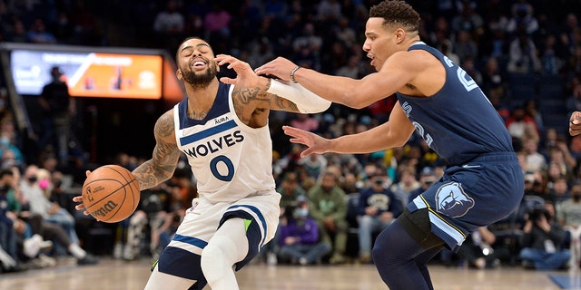 Minnesota Timberwolves guard D'Angelo Russell (0) handles the ball against Memphis Grizzlies guard Desmond Bane (22) in the second half of an NBA basketball game Thursday, Jan. 13, 2022, in Memphis, Tenn.