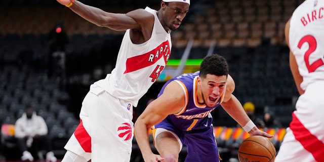 Phoenix Suns guard Devin Booker (1) drives past Toronto Raptors forward Pascal Siakam (43) during the first half in Toronto Jan. 11, 2022.