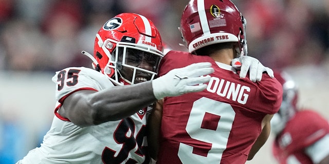 Georgia's Devonte Wyatt hits Alabama's Bryce Young as he throws during the first half of the College Football Playoff championship football game Monday, Jan. 10, 2022, in Indianapolis.