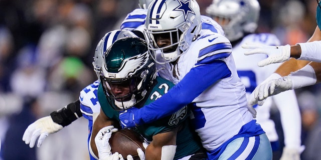 Dallas Cowboys safety Donovan Wilson tackles Philadelphia Eagles running back Jason Huntley during the first half of an NFL football game, Saturday, Jan. 8, 2022, in Philadelphia.