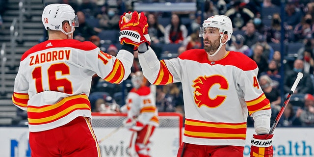 Calgary Flames' Erik Gudbranson, 对, celebrates his goal against the Columbus Blue Jackets with teammate Nikita Zadorov during the third period of an NHL hockey game Wednesday, 一月. 26, 2022, in Columbus, 俄亥俄.
