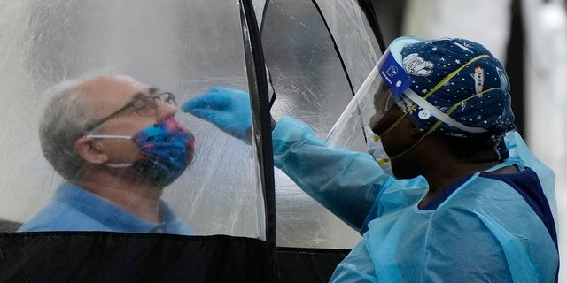 A man is tested for COVID-19 at a walk-up testing site run by Nomi Health on Dec. 28 in downtown Miami.