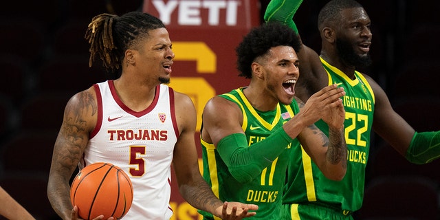 Oregon's Franck Kepnang (22) and Rivaldo Soares (11) react to a foul call on Southern California's Isaiah White (5) during the first half of an NCAA college basketball game Saturday, Jan. 15, 2022, in Los Angeles.