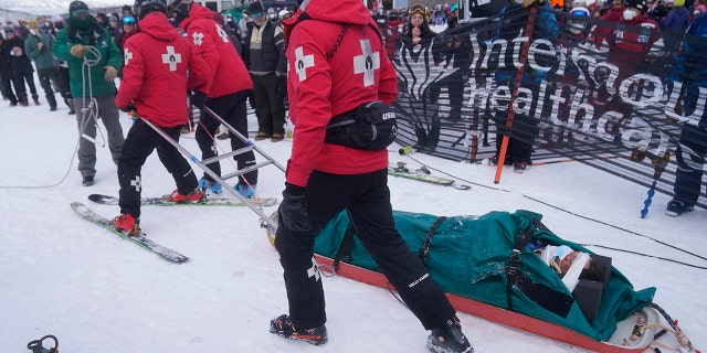 Medical officials take United States' George McQuinn off the course after he crashed at the end of a run in the finals of a World Cup freestyle moguls competition at Deer Valley Resort in Park City, Utah, Thursday, Jan. 13, 2022.
