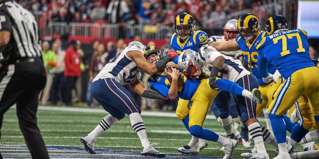 New England Patriots Dont'a Hightower (54) and Trey Flowers (98) in action, tackle vs. Los Angeles Rams QB Jared Goff (16) at Mercedes-Benz Stadium.