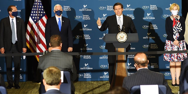 Ron DeSantis, governor of Florida, speaks while Vice President Mike Pence, second left, listens during a news conference in Tampa, Fla., July 2, 2020.